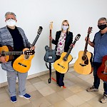 Kulturgesellschaftsgeschäftsführer Markus Müller, Verwaltungsleitung Nadine Petry und Musikschuldozent Peter Knerner freuen sich über die Gitarren
